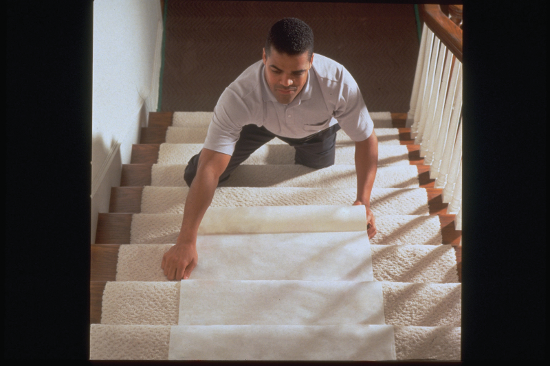 Man installing a floor runner to protect carpeting